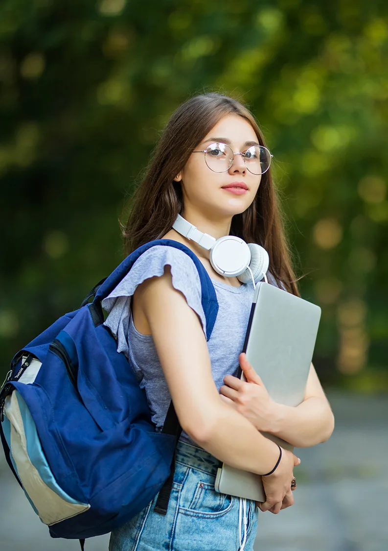 Estudiante sonriendo mientras estudia con su portátil